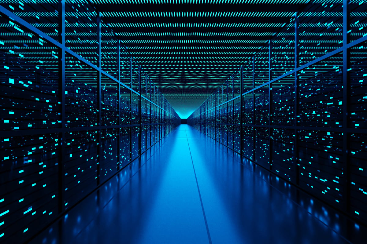 Server racks full of routers, switches and servers aligning on both sides of an aisle of a data center